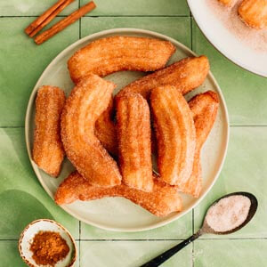 Deze knapperige churro’s, omhuld met een zoete laag kaneelsuiker brengen de geur van de herfst recht naar je keuken.